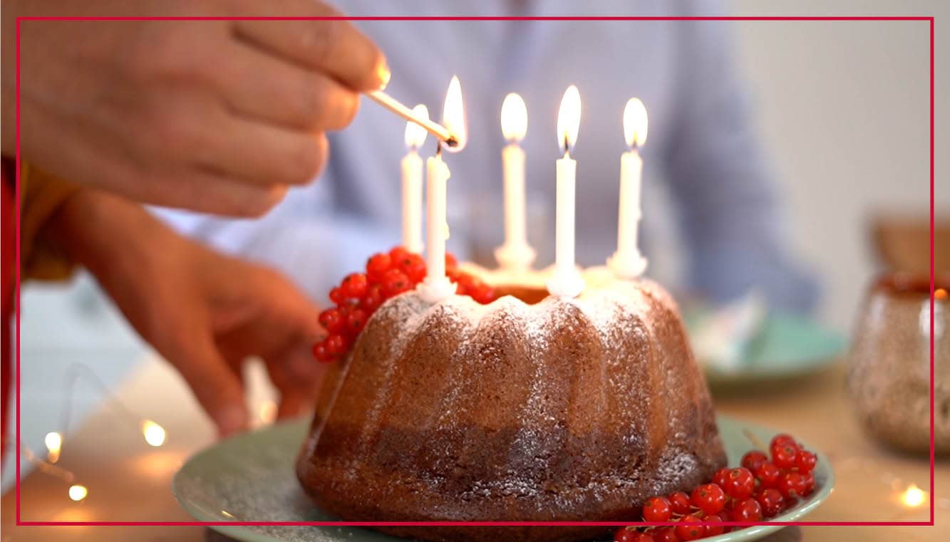 Kuchen mit brennenden Geburtstagskerzen