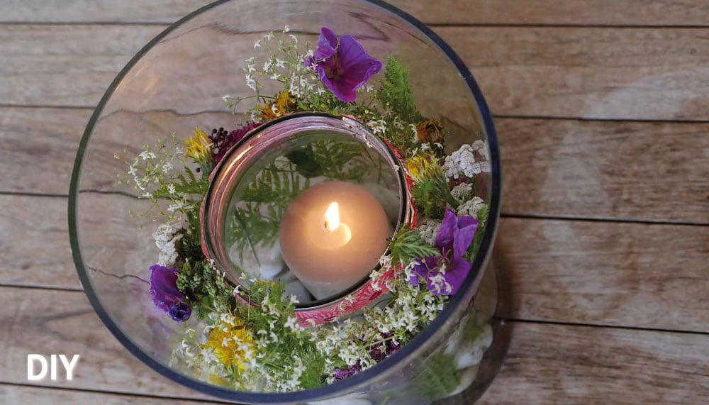 Glas im Glas Dekoration mit Blumen, Steinen und Kerze