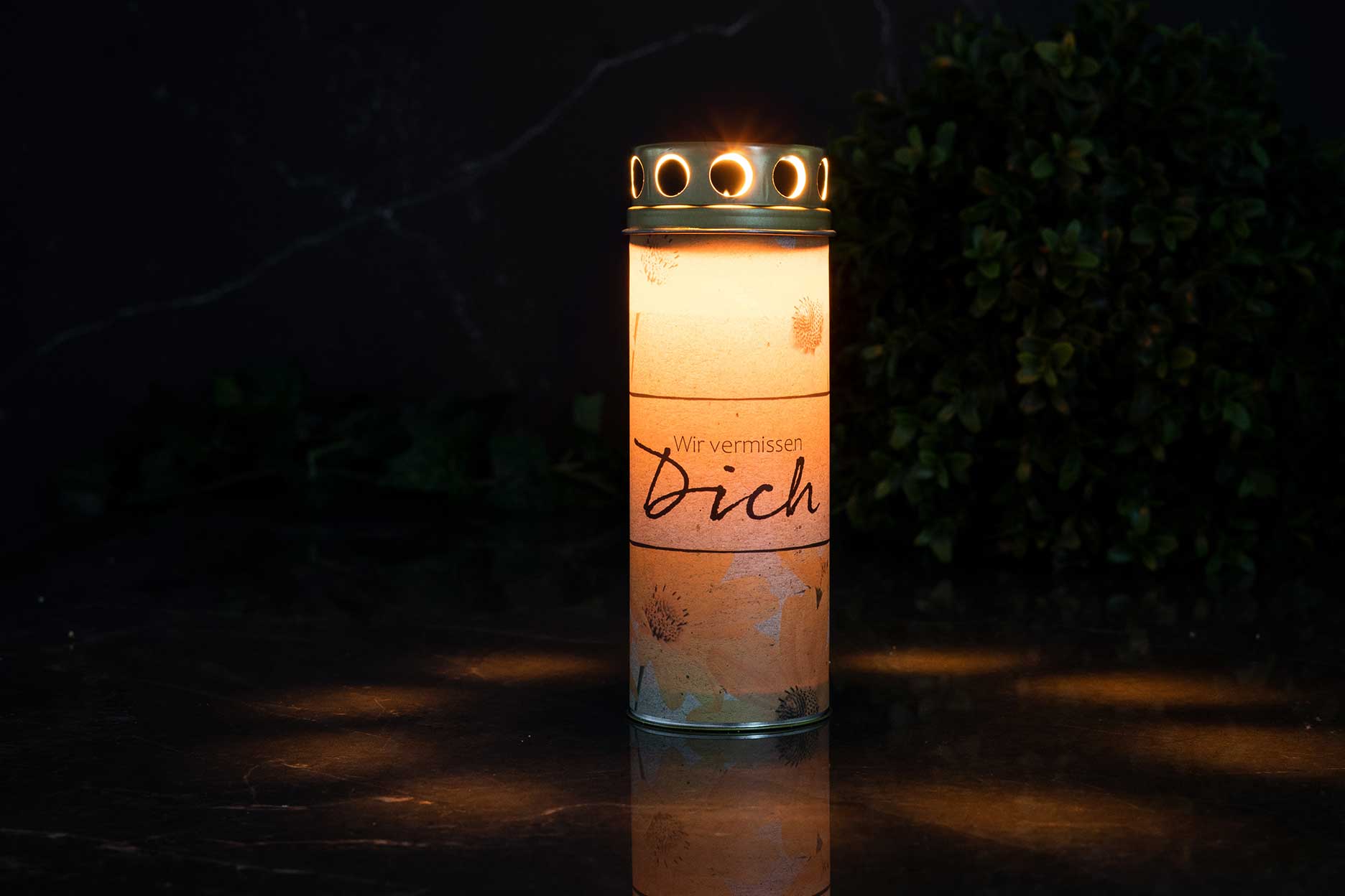 Grablicht aus Papier bei Nacht Grablicht aus Papier leuchtet in der Dunkelheit auf einem Grab