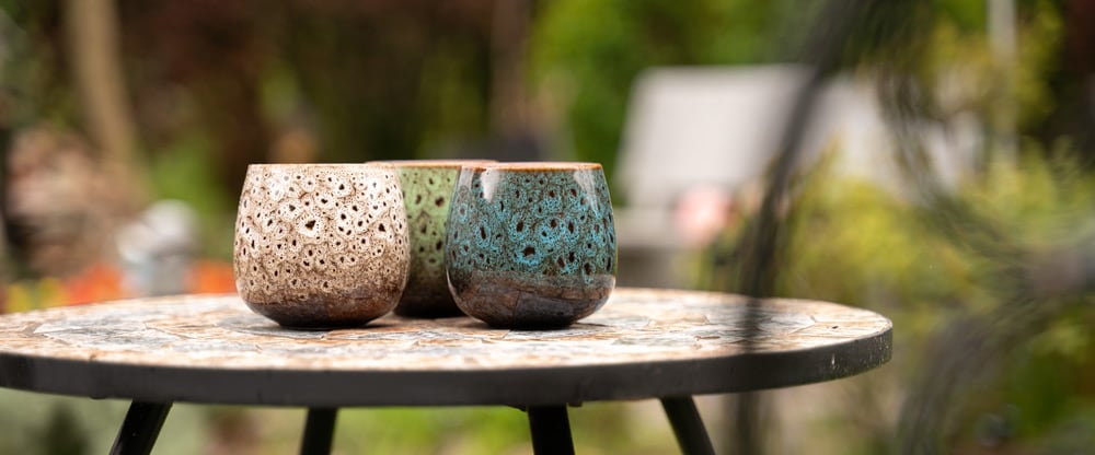 Bunte Keramikschalen auf Gartentisch
