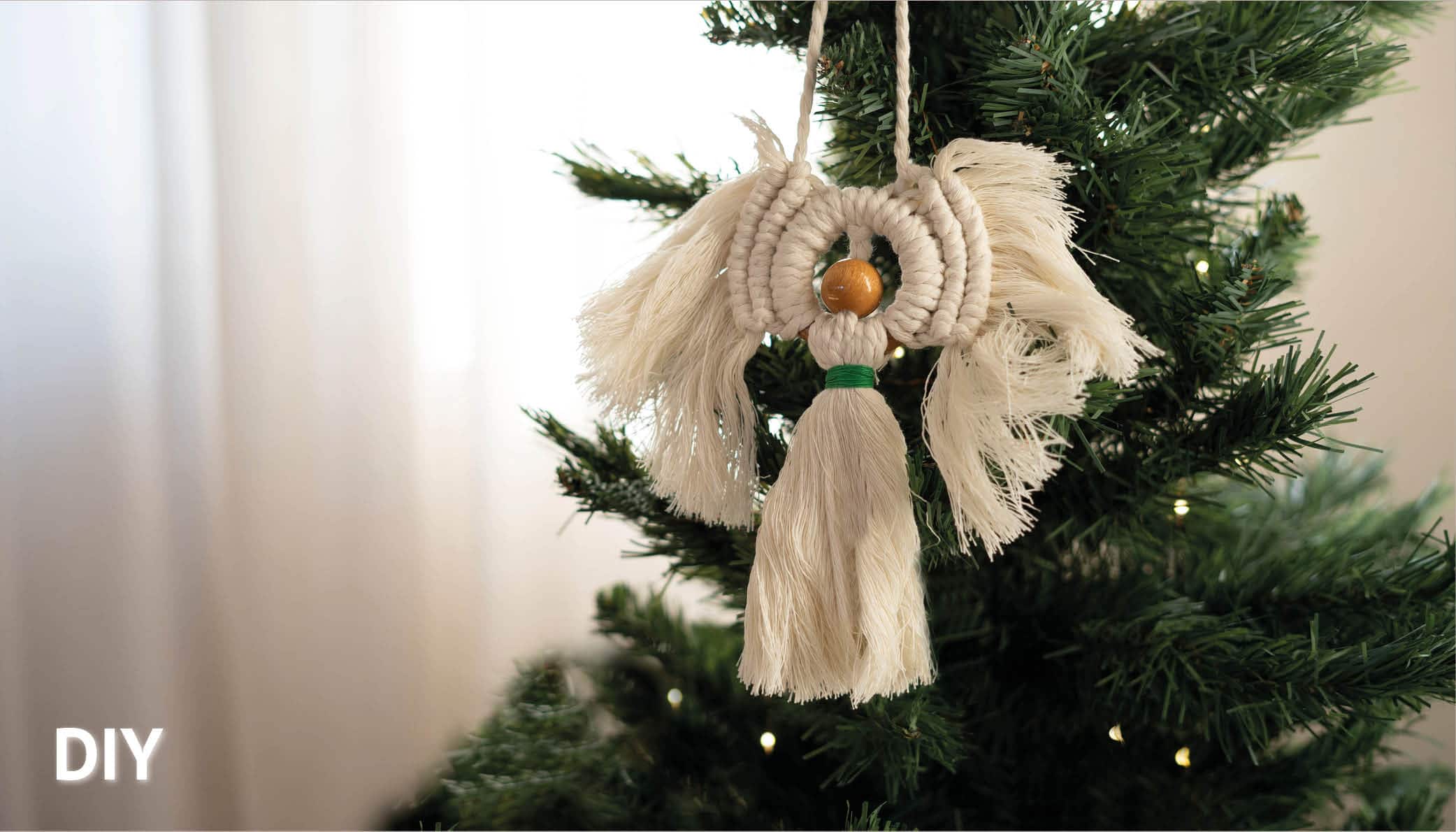 Makramee Engel in weiß auf Christbaum hängend