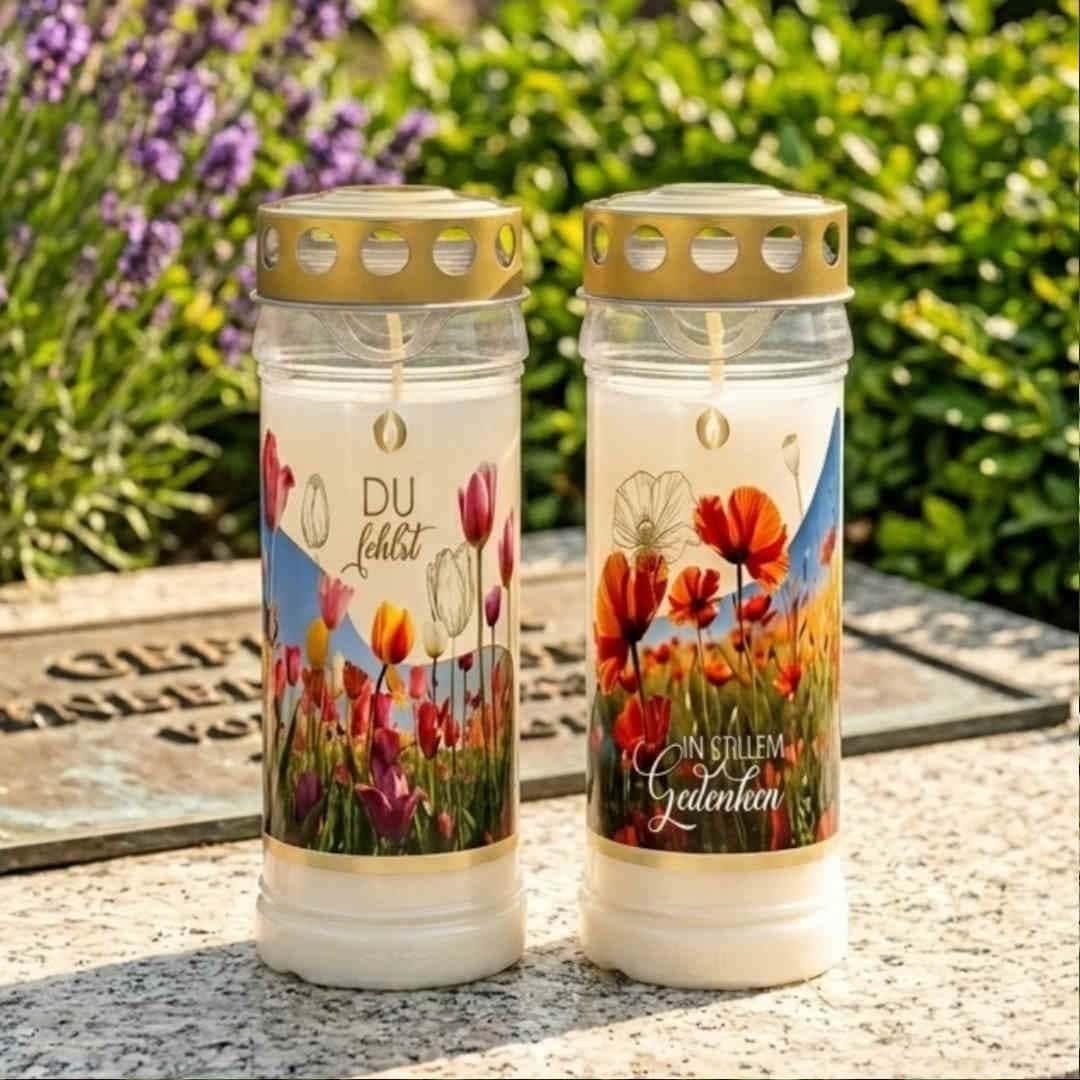 Zwei Grablichter auf Grabplatte, Tulpen- und Mohnetikett, Aufschriften „Du fehlst" und „In stillem Gedenken"