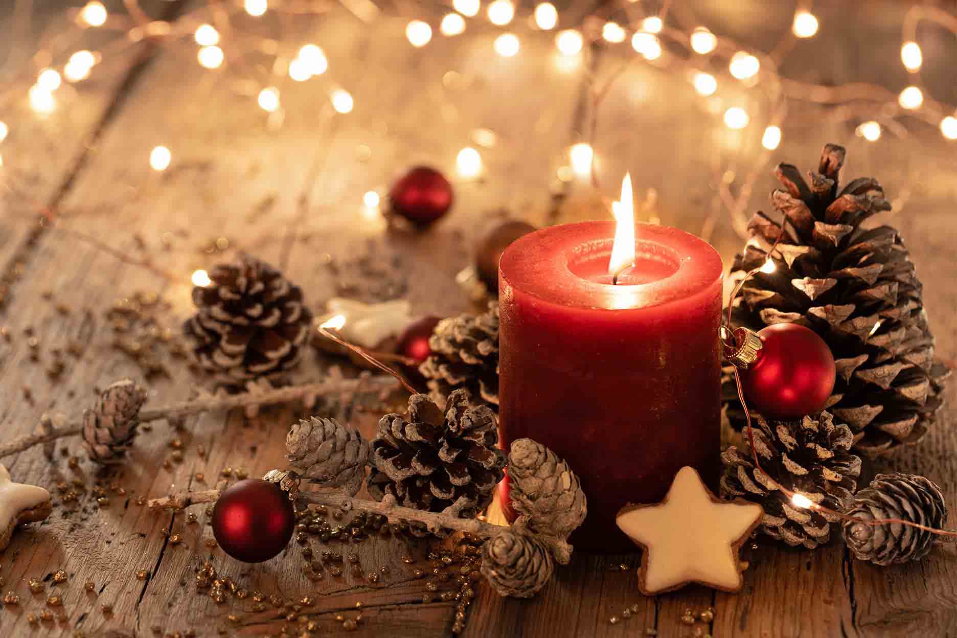 Kerze und Weihnachtsdekoration auf einem Holztisch