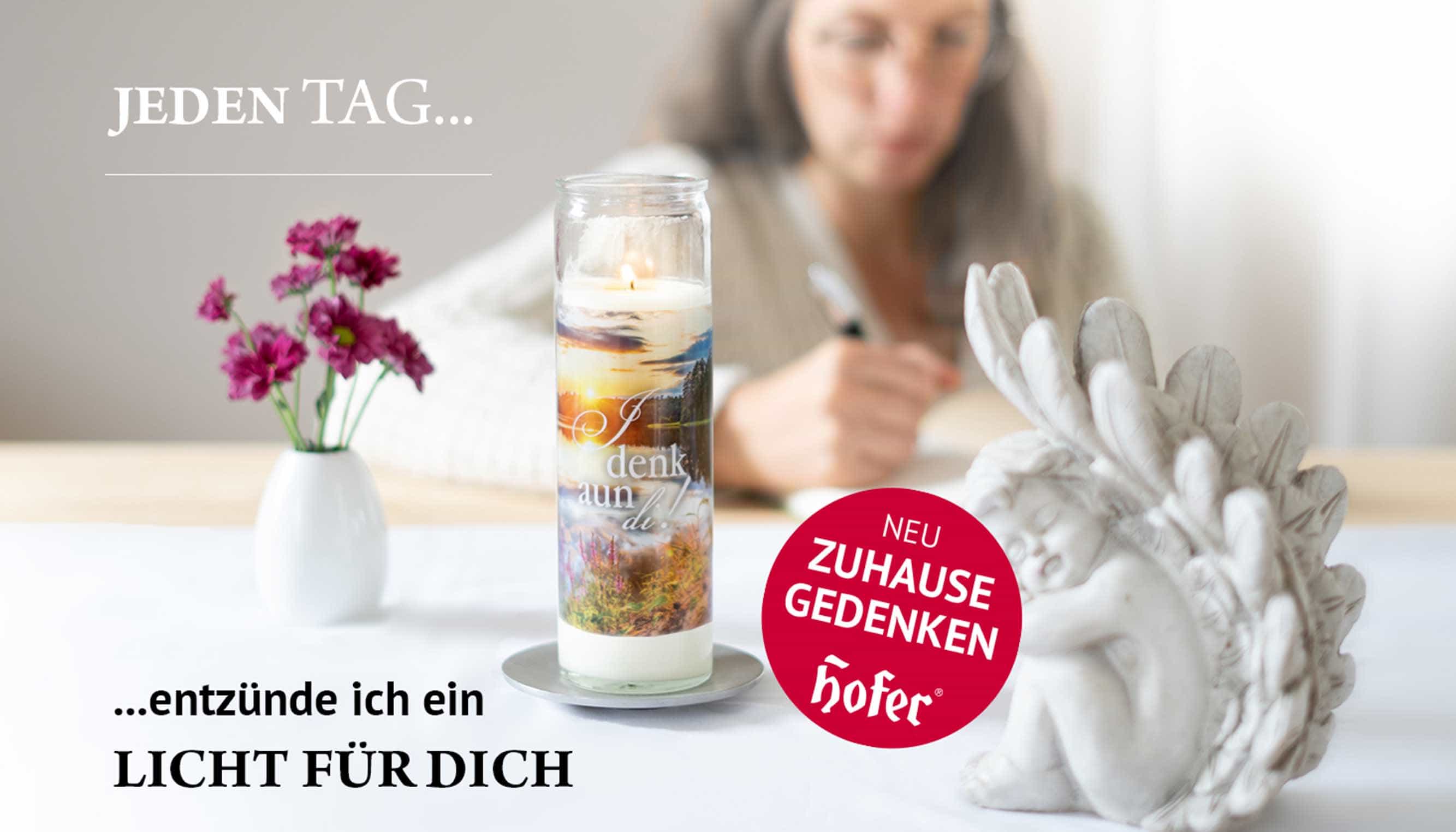 Zuhause gedenken mit Gedenkkerzen von Hofer-Kerzen Gedenkkerze mit dem Spruch, I denk aun di, vor einer Frau auf einem Tisch